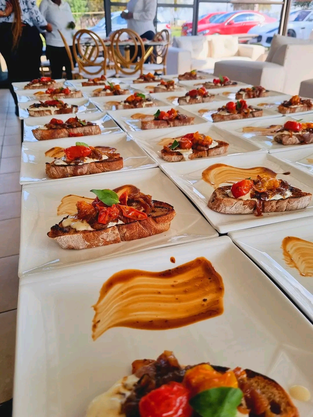 Rows of bruschetta with roasted cherry tomatoes and balsamic art for prestige event service