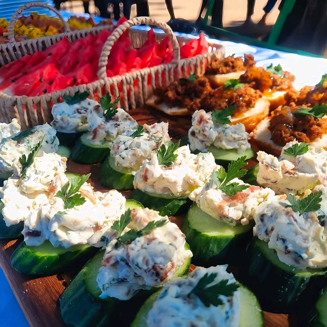 Cucumber canapés with cream cheese and herb at outdoor event