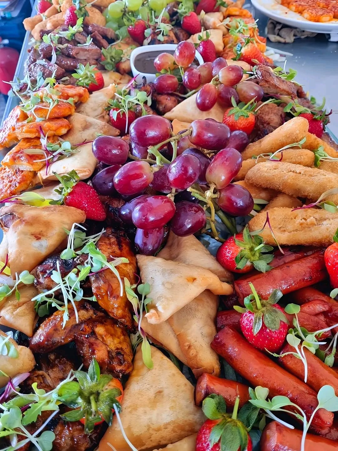 Event grazing platter with cherries, samosas and finger foods