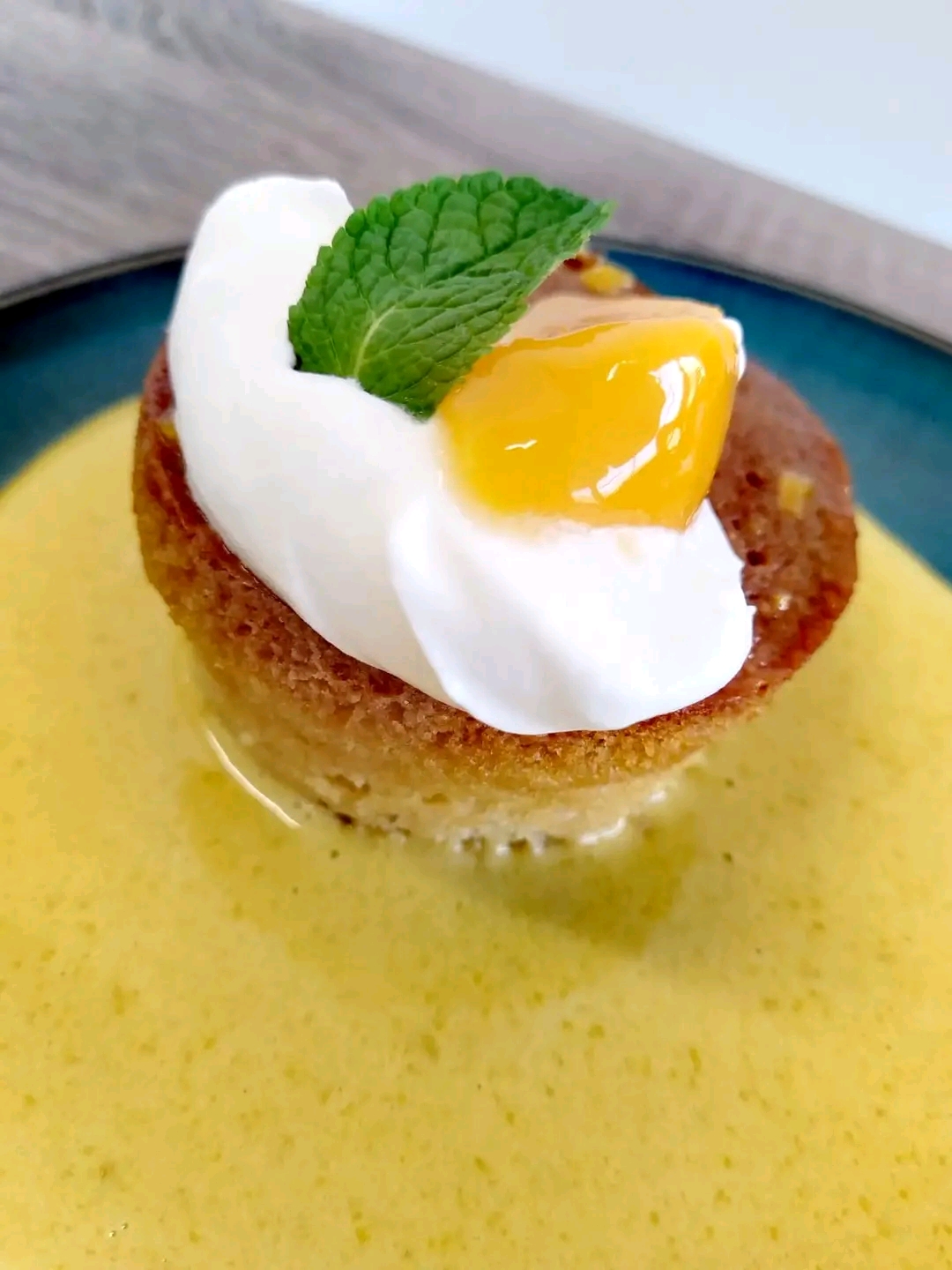Lemon sponge with mango coulis on blue ceramic plate