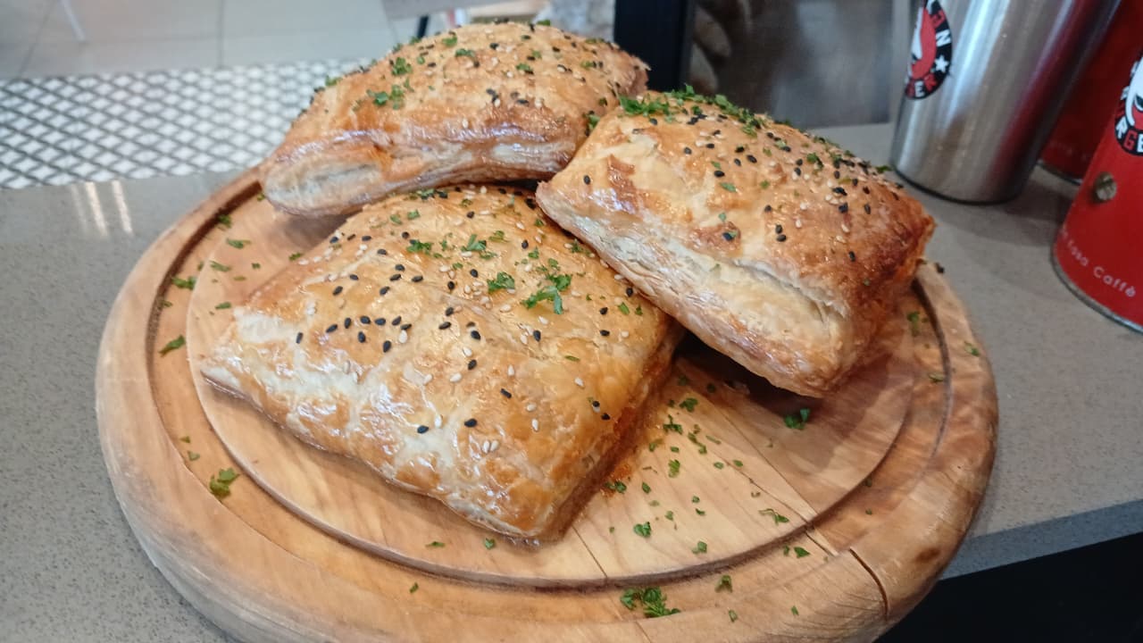 Golden puff pastries with sesame seeds and fresh herbs