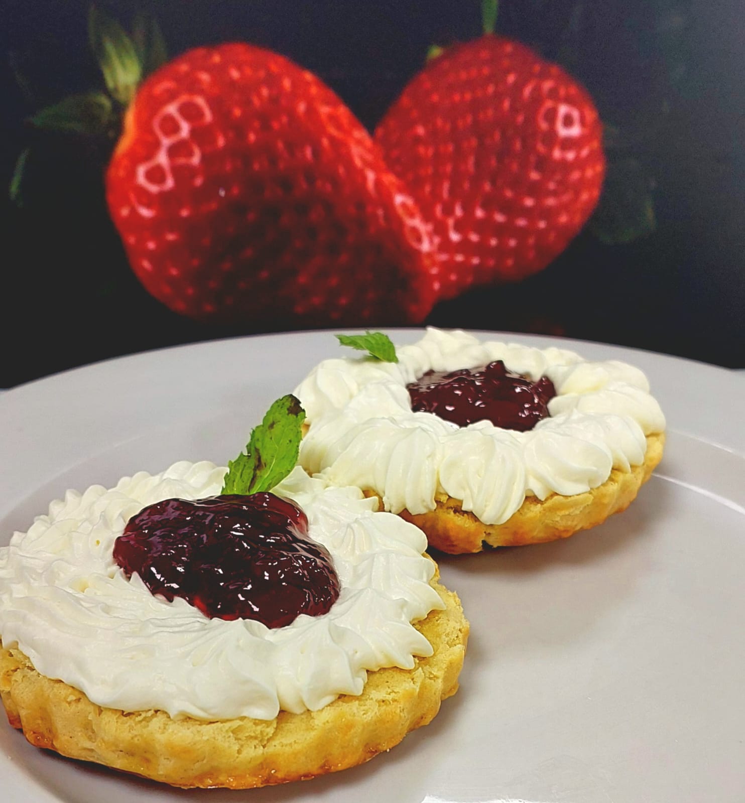 Freshly baked scones with whipped cream and dark berry compote